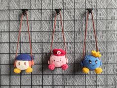 three small crocheted toys hanging from hooks