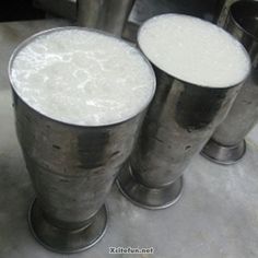 three metal cups filled with white liquid