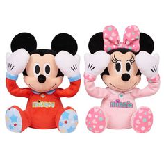 two mickey and minnie mouse stuffed animals sitting next to each other on a white background