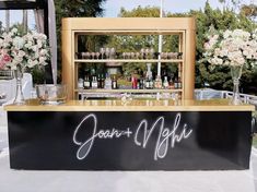 an outdoor bar with flowers and vases on it