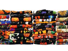 a stack of halloween themed scarves on display in front of a white background,