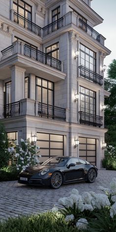 a black sports car is parked in front of a large building with balconies