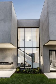 an exterior view of a modern house with grass and stairs