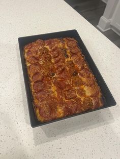 a square shaped pizza sitting on top of a counter next to a white countertop