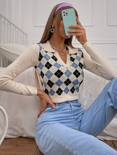 a woman sitting on the floor taking a selfie with her cell phone in front of her face