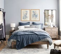 a bed room with a neatly made bed next to a window and a rug on the floor