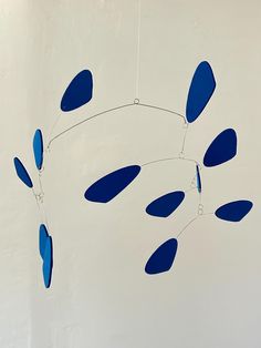 a blue wind chime hanging from a white wall