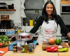 a woman standing in a kitchen with lots of food on the counter and cooking utensils