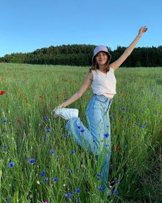 a woman is standing in the middle of a field