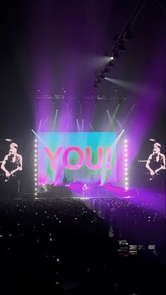 the stage is lit up with purple and green lights