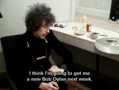 a man sitting in front of a bathroom sink next to a mirror with the words i think i'm going to get me a new bob dylan next week