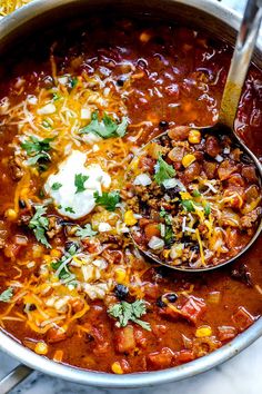 a spoon full of chili and cheese soup