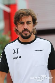 a man with long hair wearing a white and black shirt