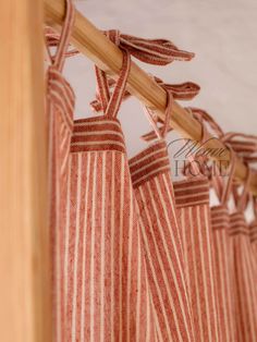 red and white striped curtains hanging from a wooden pole