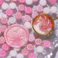 two pink and white items sitting on top of a flowery table cloth next to each other