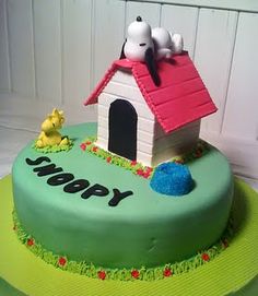 a birthday cake decorated with a dog house and three little dogs on the roof that says happy