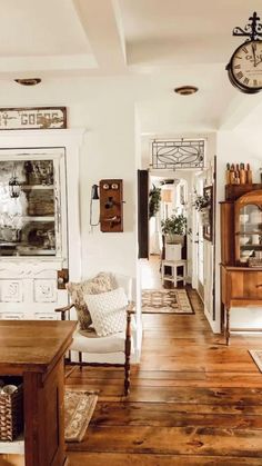 a living room filled with furniture and a large clock on the wall above it's doorway