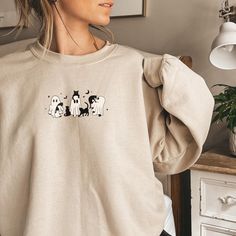 Halloween Gift For Cat Owners | Ghost Holding Black Cats Halloween Sweater | Spooky Season | Cute Ghost Holding Cat Sweatshirt Embrace the spirit of spooky season with our delightful ghosts holding cats sweatshirt! Perfect for Halloween, this charming sweater features an adorable design of a ghost gently cradling a black cat, making it an ideal gift for cat lovers. Whether you're attending a Halloween party or enjoying a cozy night in, this Halloween sweatshirt combines comfort and style in a fun way. Made from soft materials, it's perfect for layering during fall chill. Show off your love for black cats and ghosts with this unique Halloween crewneck that stands out in any casual setting. Get ready to celebrate the season with our cat ghost sweatshirt and make it your go-to Halloween attir White Cat Design Sweatshirt For Fall, Fall Crew Neck Sweater With Cat Design, Black Cats Halloween, Ghost Crewneck, Casual Halloween Sweatshirt With Cat Print, Ghost Sweater, Cats Halloween, Halloween Cat Print Crew Neck Sweatshirt, Cat Ghost