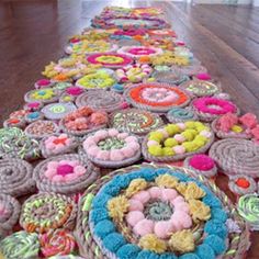 a long row of crocheted baskets filled with donuts on top of a wooden floor