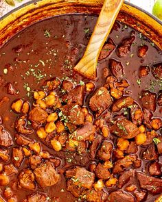 a pot filled with meat and beans on top of a table