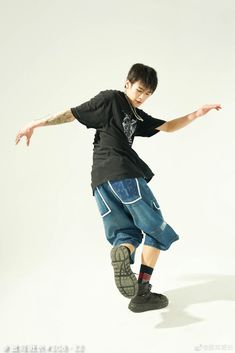 a young man riding a skateboard on top of a white surface with his arms outstretched