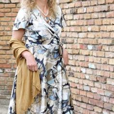 a woman standing in front of a brick wall