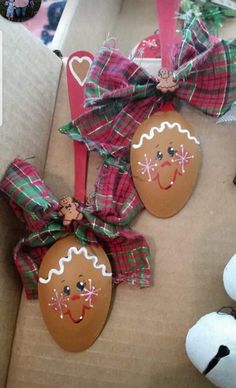 two gingerbread man ornaments are sitting on a cardboard box with ribbons and bows around them