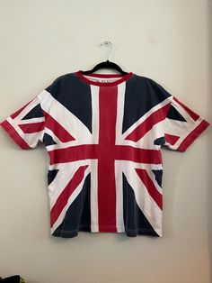 a t - shirt hanging on a wall with the flag of england painted on it