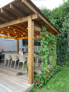 an outdoor kitchen and dining area with string lights strung across the pergolated roof