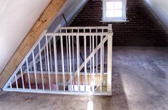 an attic loft with exposed brick walls and white railings