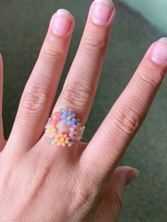 a woman's hand holding a ring with flowers on it