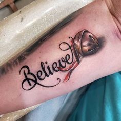 a man with a tattoo on his arm that says believe and a bell in the middle