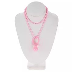 a white mannequin with pink beads and a pink ribbon on the front of it