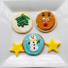 three decorated cookies on a white plate