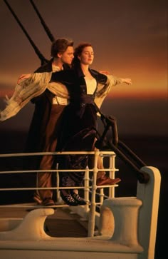 two people standing on the deck of a ship