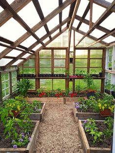 a greenhouse filled with lots of plants and flowers