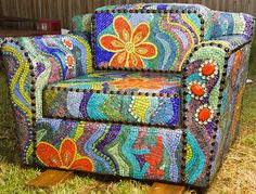 a colorful chair sitting on top of a grass covered field