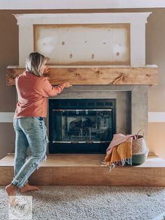 a woman standing in front of a fire place