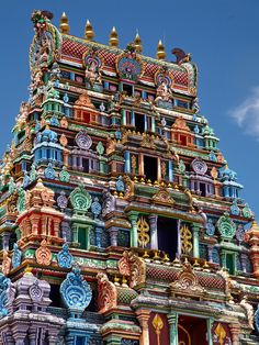 an elaborately decorated tower with clocks on it's sides and windows in the middle