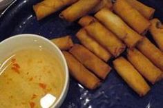 some food is laying out on a blue plate next to a white bowl and spoon