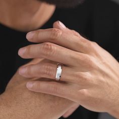 a man wearing a wedding band with his hand on the other side of his ring