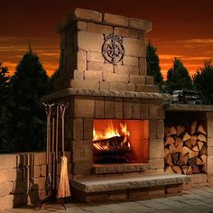 an outdoor fireplace with fire and logs in it