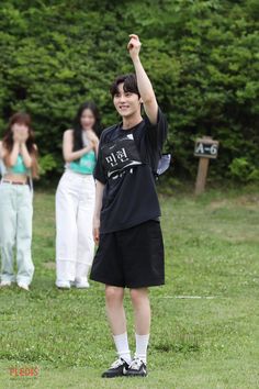 a young man standing on top of a lush green field