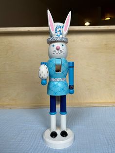 a blue and white rabbit figurine holding a nutcracker