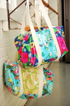 three colorful bags hanging from the side of a brick wall, with text overlay that reads ruffle butterfly bag by family ever after