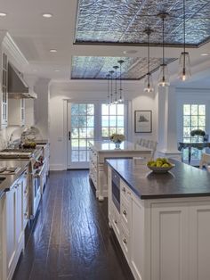 a large kitchen with wooden floors and white cabinets