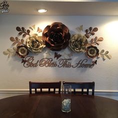 a wooden table topped with a vase filled with water next to a wall mounted flower