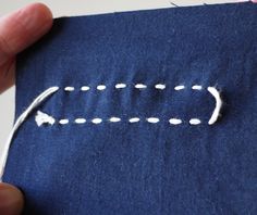 someone is stitching an arrow on a piece of fabric