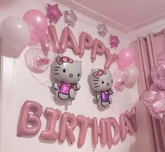 a hello kitty birthday party with pink balloons and heliums on the wall above it