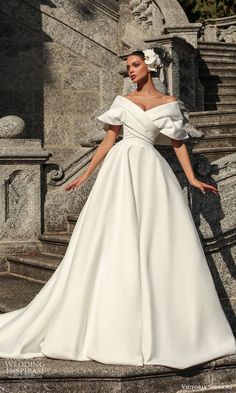 a woman in a white dress standing on steps